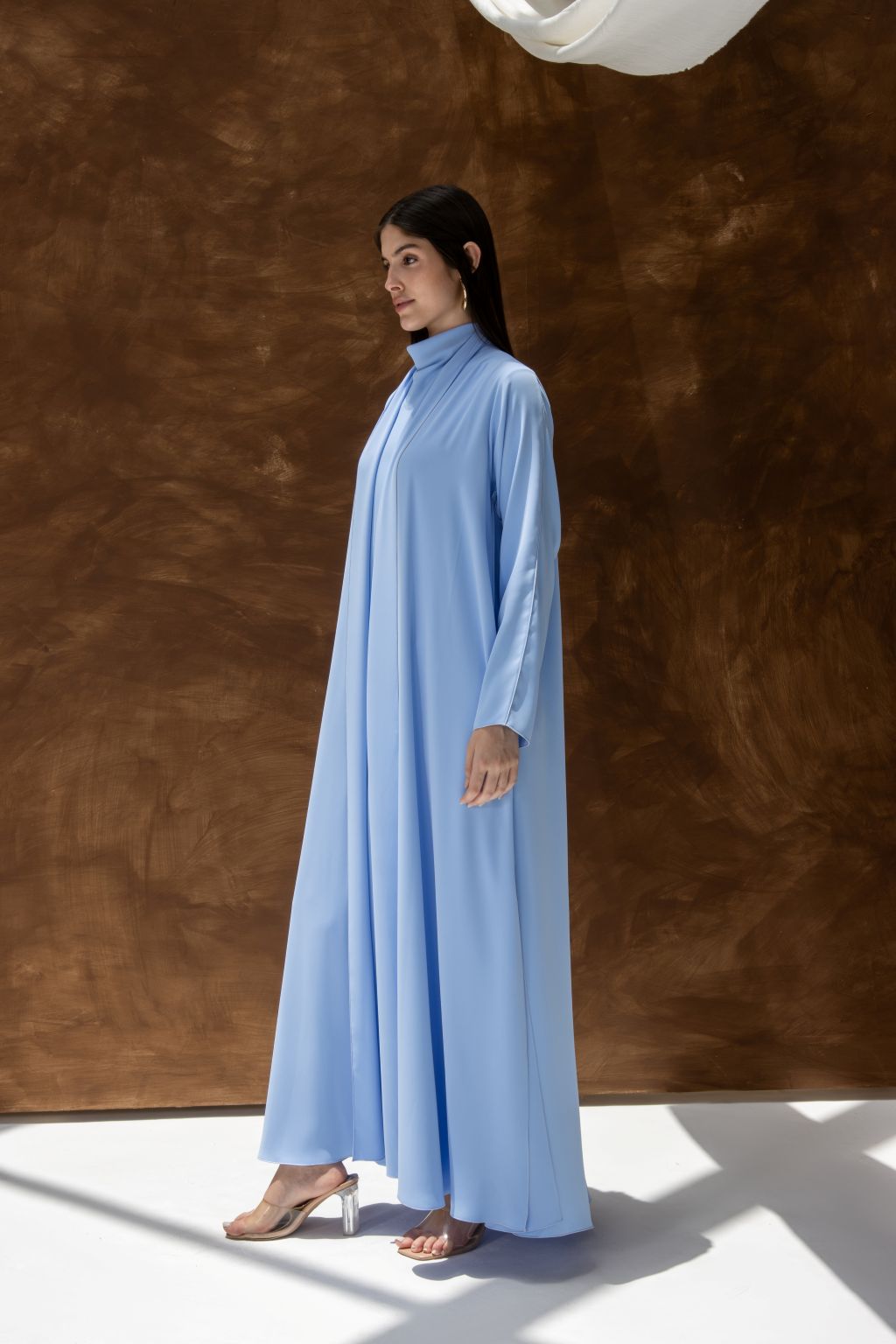 Selected Lines light blue abaya styled as a classic evening dress for special occasions with long sleeves and high neck