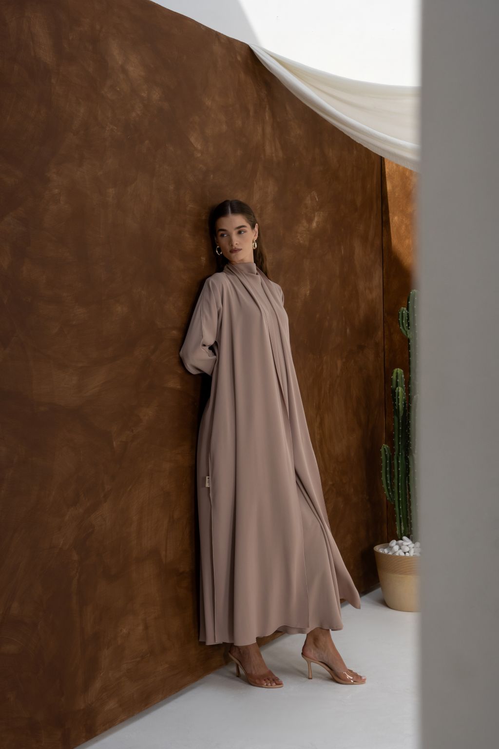 Selected Lines taupe abaya styled as a classic evening dress for special occasions with long sleeves and modest design