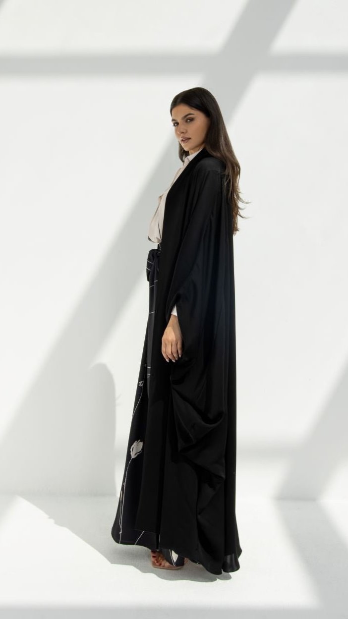 Woman wearing luxury Al Zain Abaya in black with flowing fabric by Selected Lines