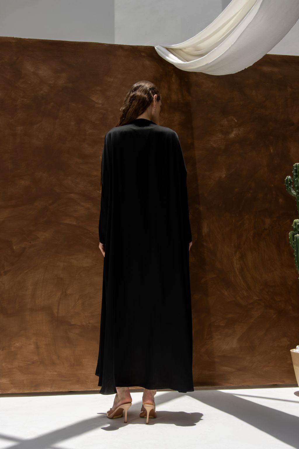 Selected Lines black Bahraini abaya for women shown from the back with long sleeves and flowing fabric