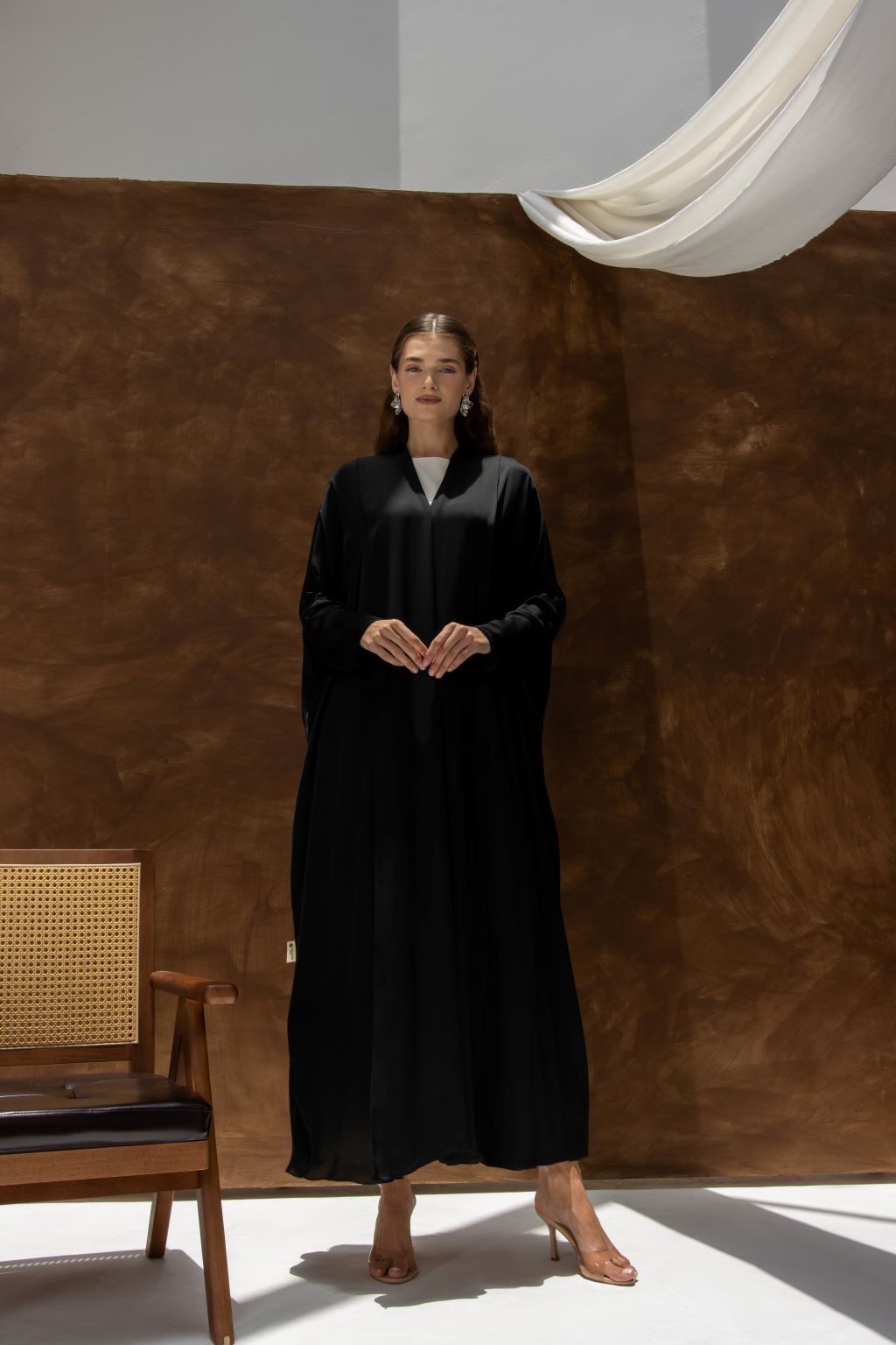 Selected Lines black Bahraini abaya for women with a modest design worn by a model in a studio setting