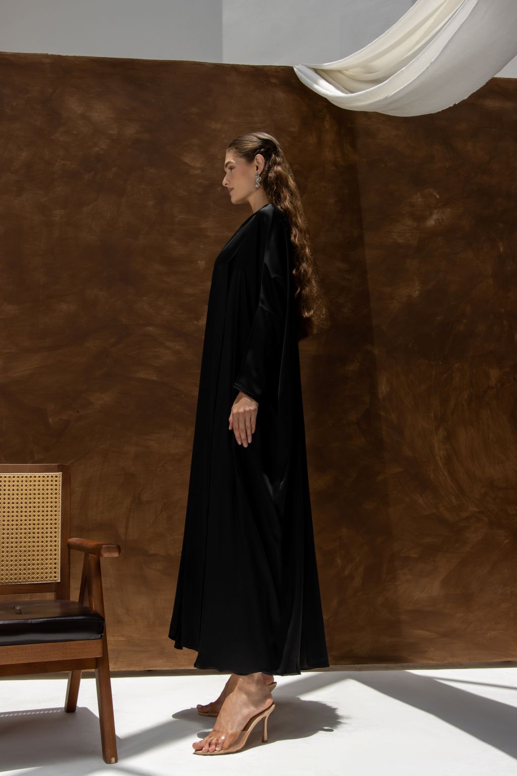 Selected Lines Bahraini abaya for women in black flowing fabric worn with beige heels