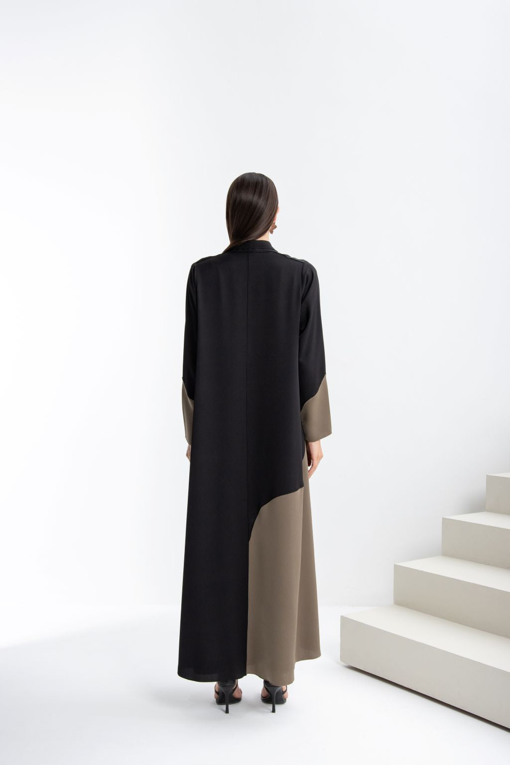 Back view of a black designer abaya high quality with contrasting beige paneling, stylish and elegant design