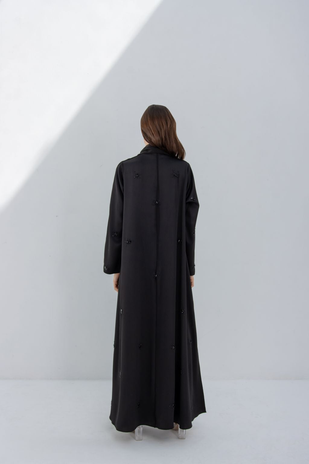 Selected Lines black formal abaya for women shown from the back with long sleeves and a flowing design