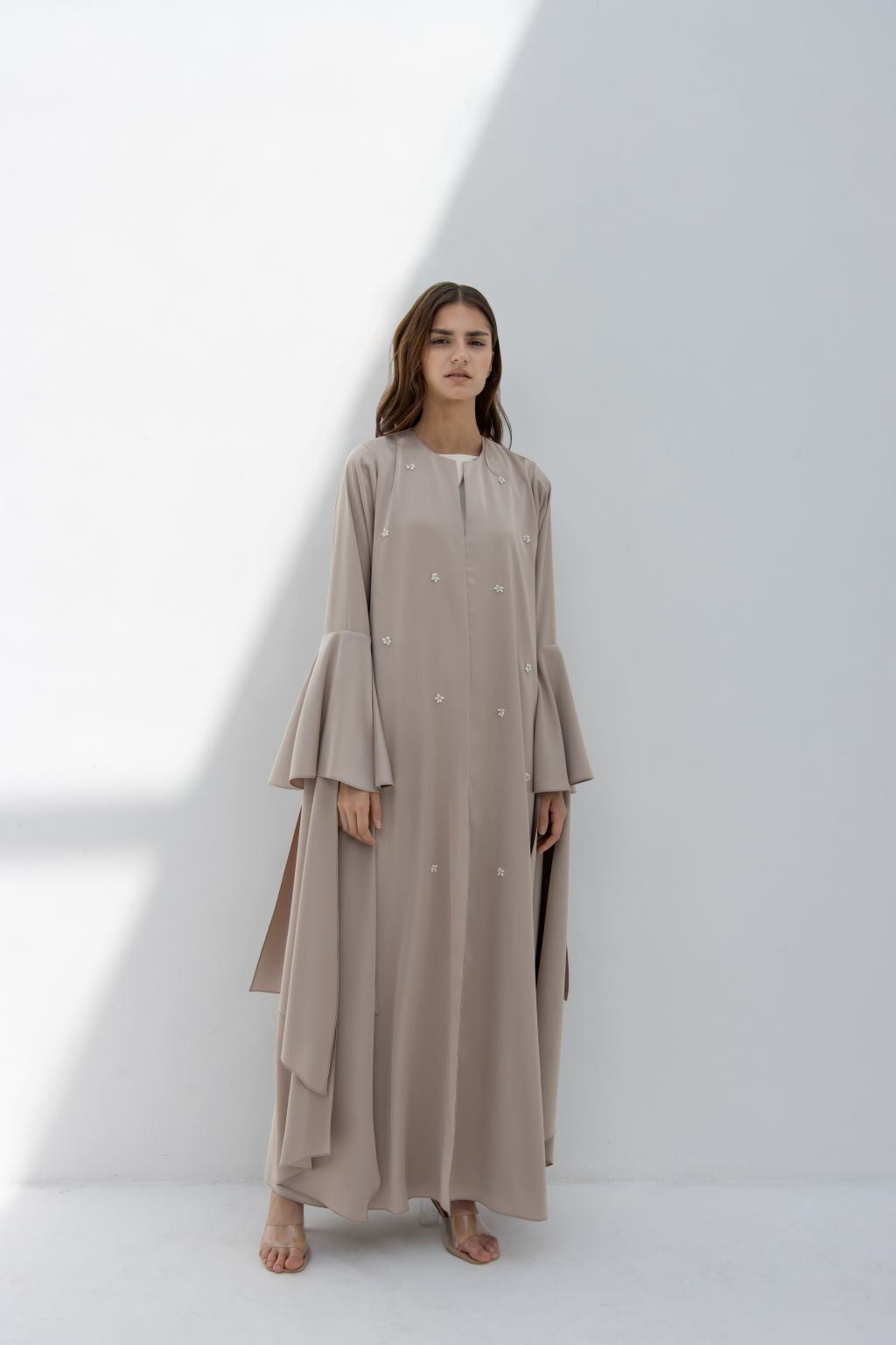 Model wearing an elegant seashell dress by Selected Lines with long sleeves and flowing design