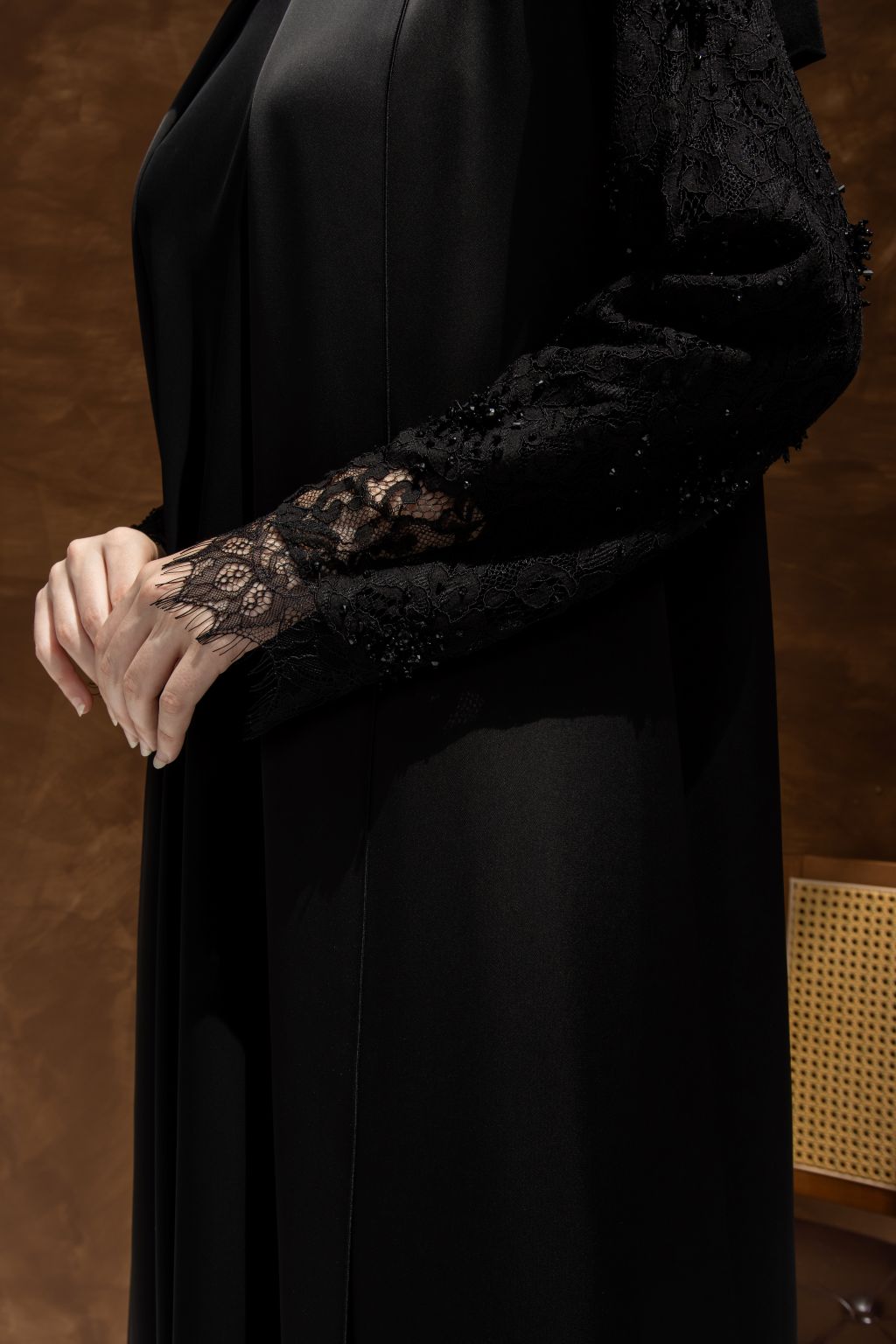 Elegant black evening dress featuring intricate lace details on the sleeves for a sophisticated look
