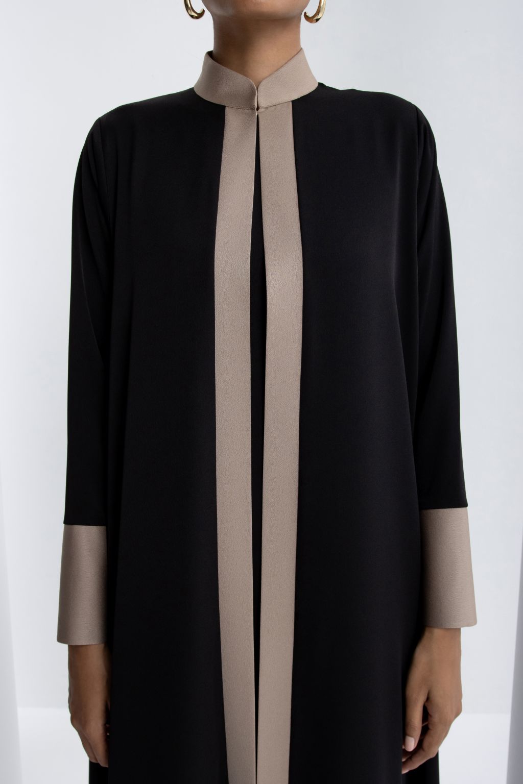 Elegant black modest abaya featuring a stylish zipper neck and contrasting beige details