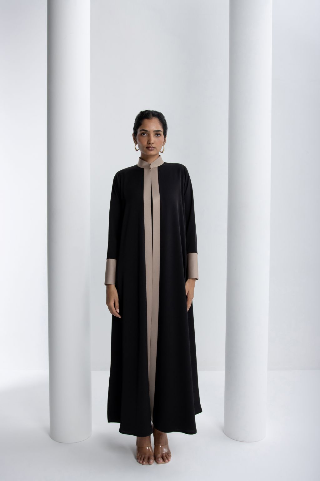 Elegant black modest abaya with contrasting beige accents and a flowing silhouette