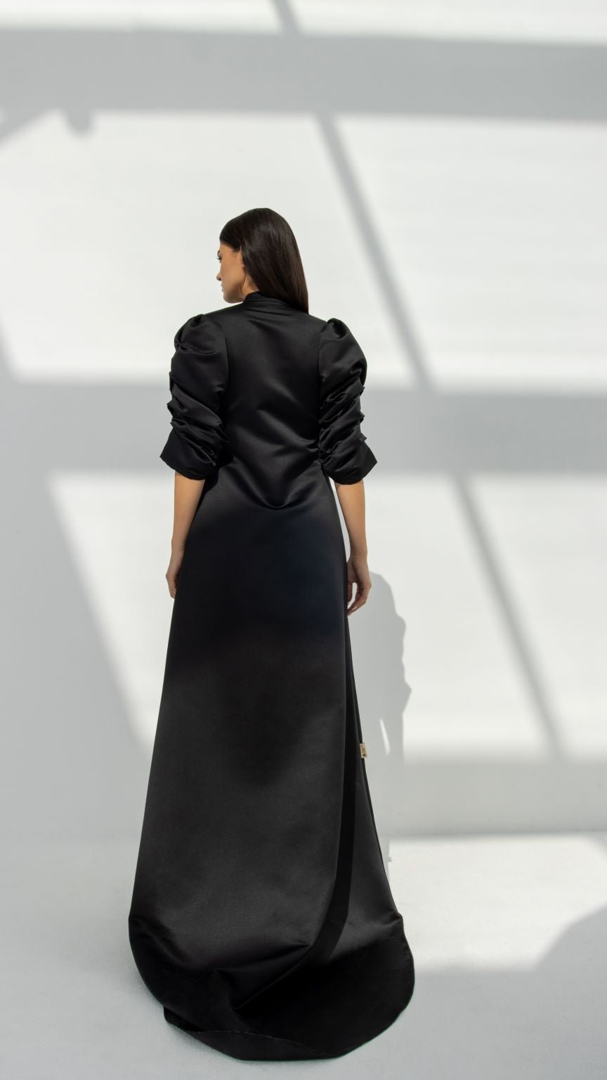 Selected Lines elegant button line dress in black satin with long puff sleeves and a floor-length silhouette
