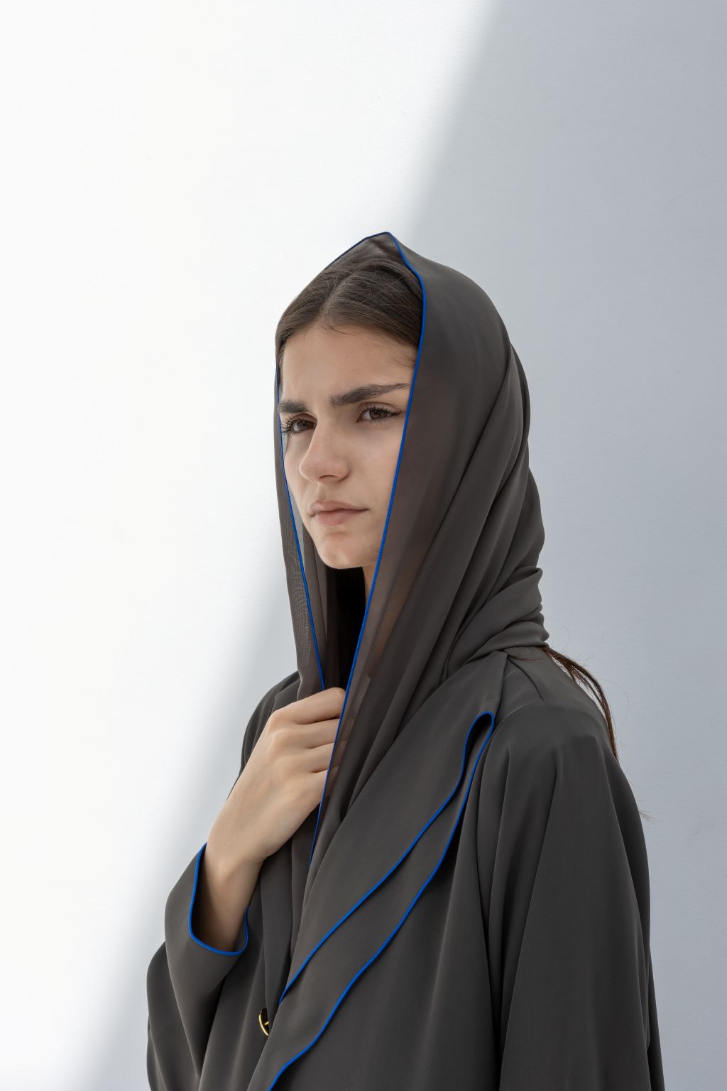 Selected Lines elegant Curve Buttons abaya in dark fabric with blue trim worn by model