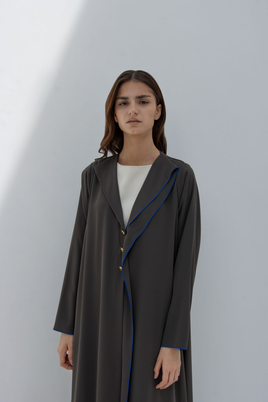 Selected Lines elegant Curve Buttons abaya in dark color with blue edge detailing and gold buttons