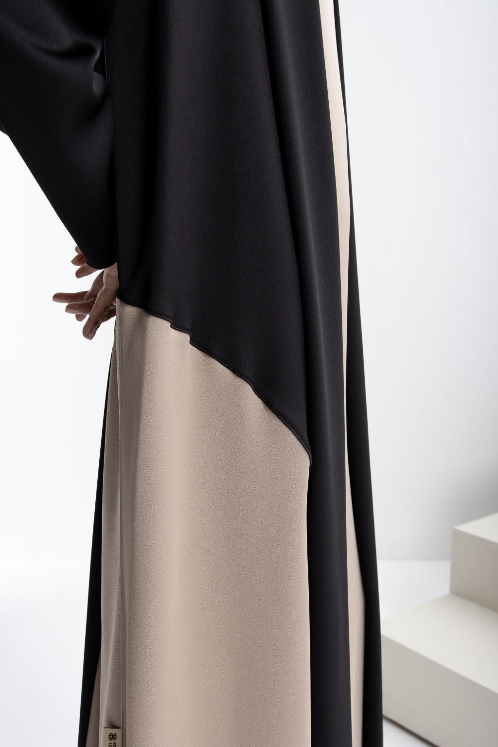 Elegant modest fashion dress in black and beige with flowing design for a sophisticated look