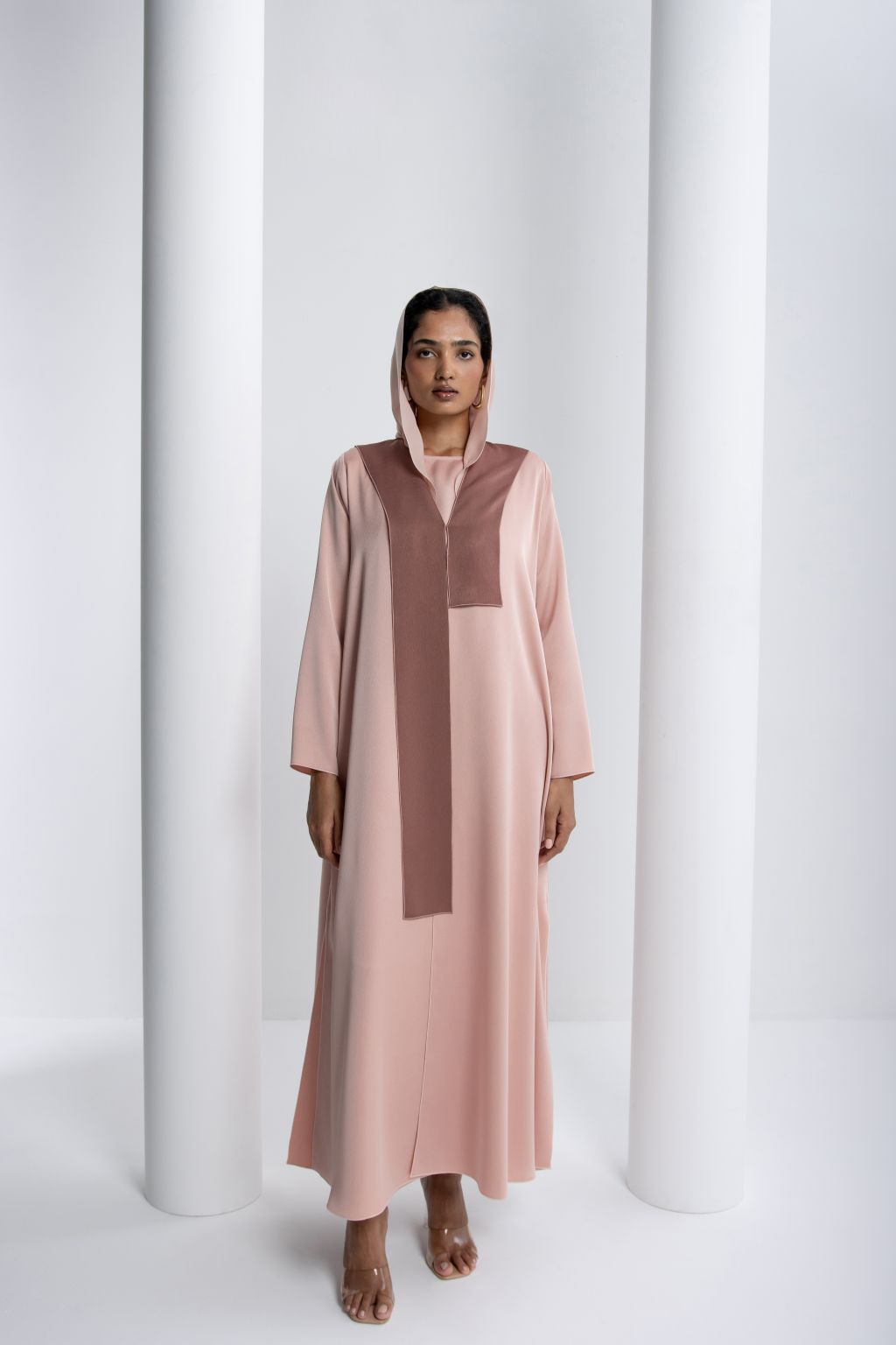 Elegant modest fashion dress in soft pink with a contrasting brown panel and hooded design