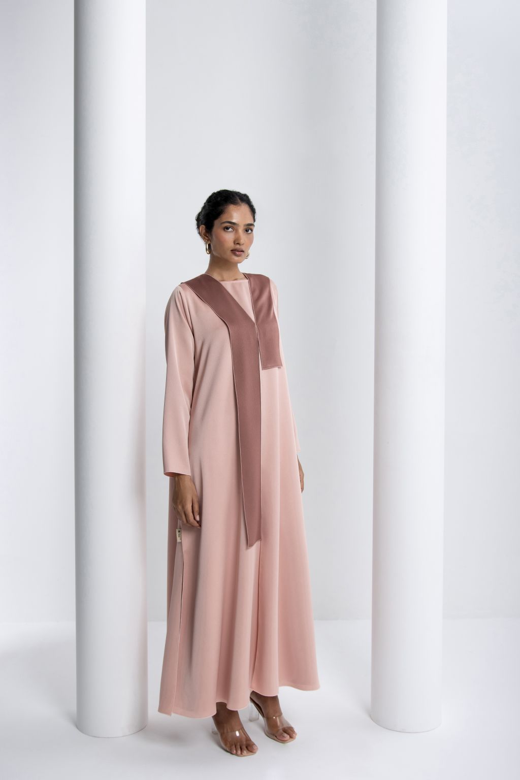 Elegant modest fashion dress in soft pink with a contrasting brown accent, perfect for special occasions