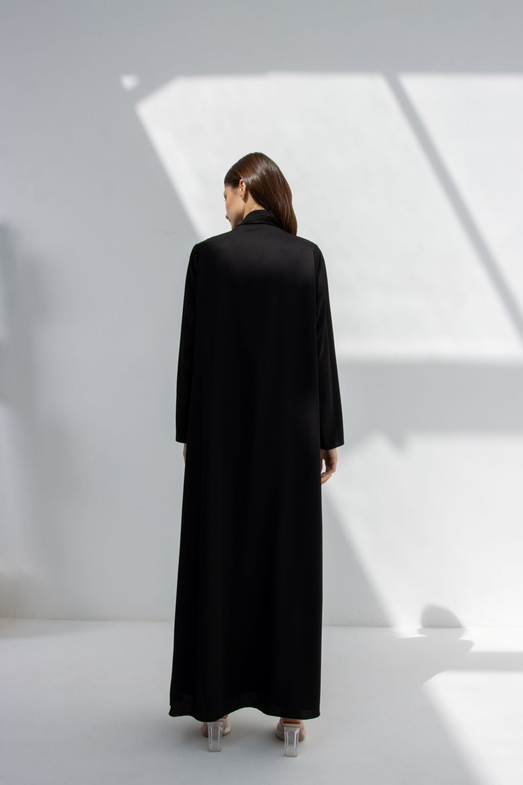 Selected Lines elegant purple abaya shown from the back in black fabric on model with natural light