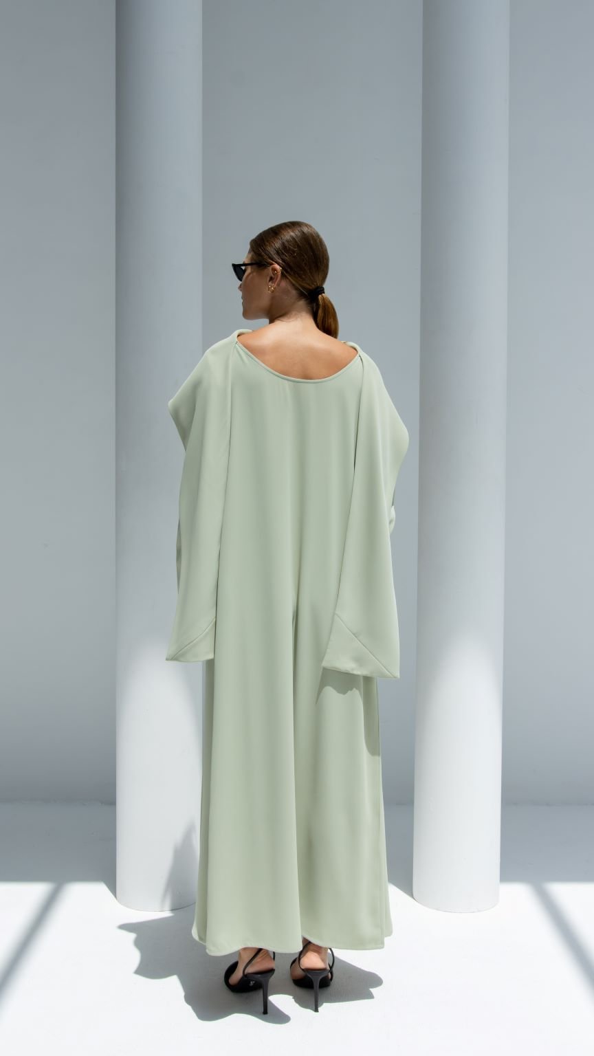 Model wearing an elegant scarf dress in light green showcasing a relaxed fit and flowy design