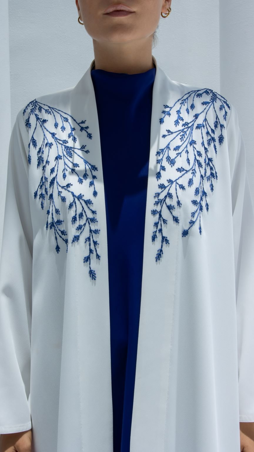 Close-up of Fine Leaves Abaya’s delicate leaf embellishments on premium white crepe fabric | Selected Lines