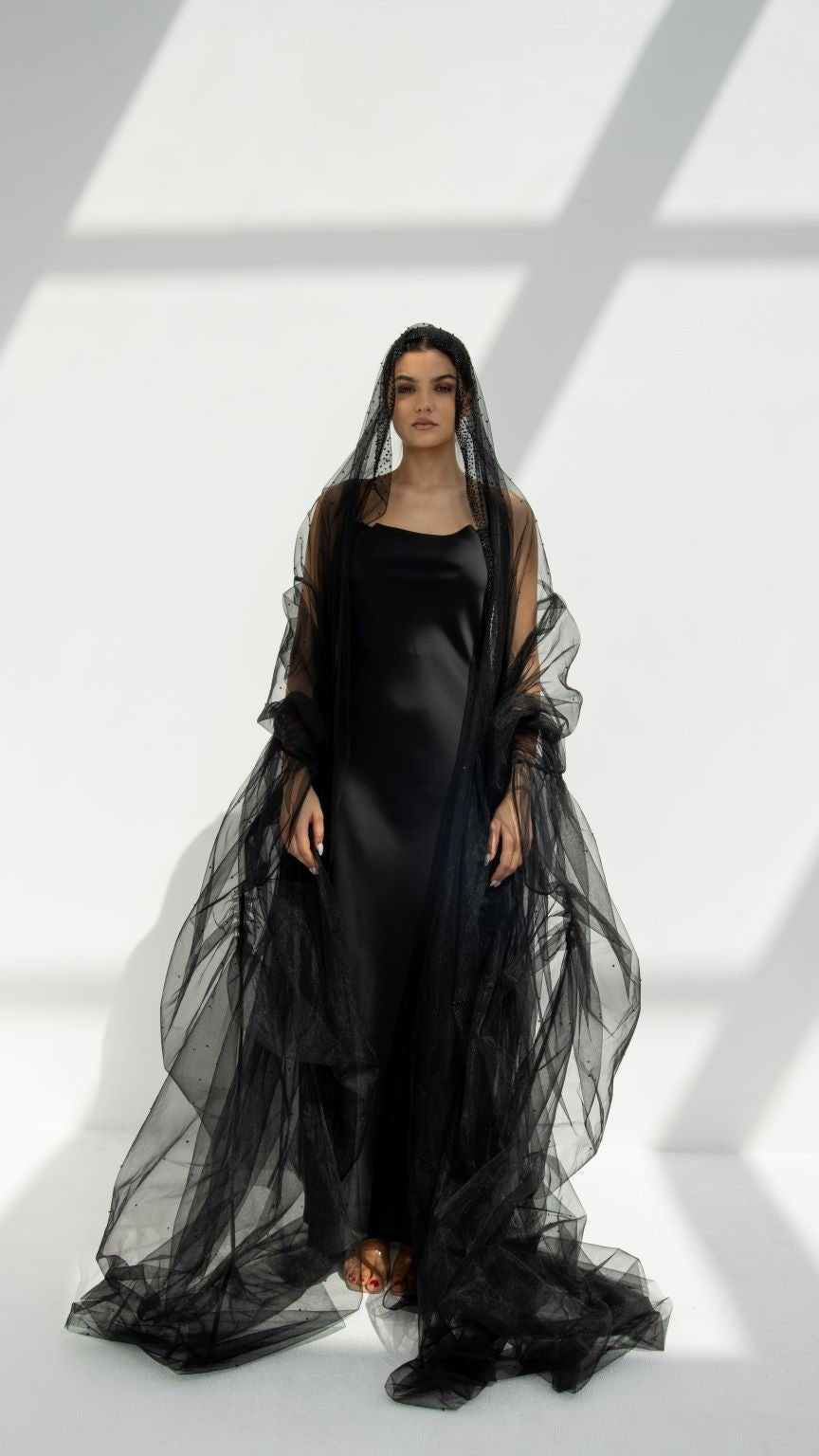 Georgina Abaya elegant design featuring a flowing black fabric with a layered cape for a sophisticated look