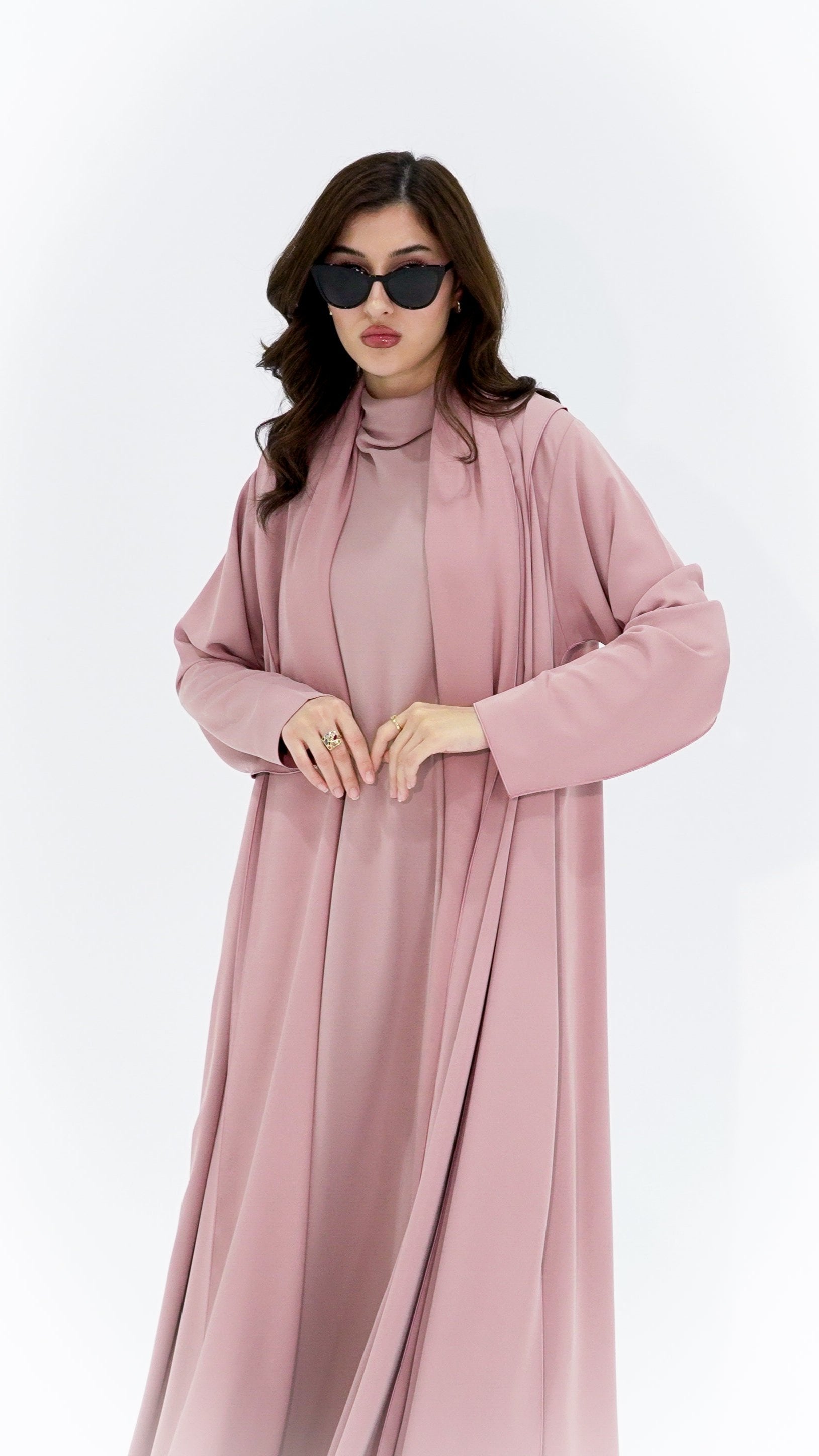 Elegant woman wearing a high quality Arabic abaya in soft pink for stylish and modest occasions