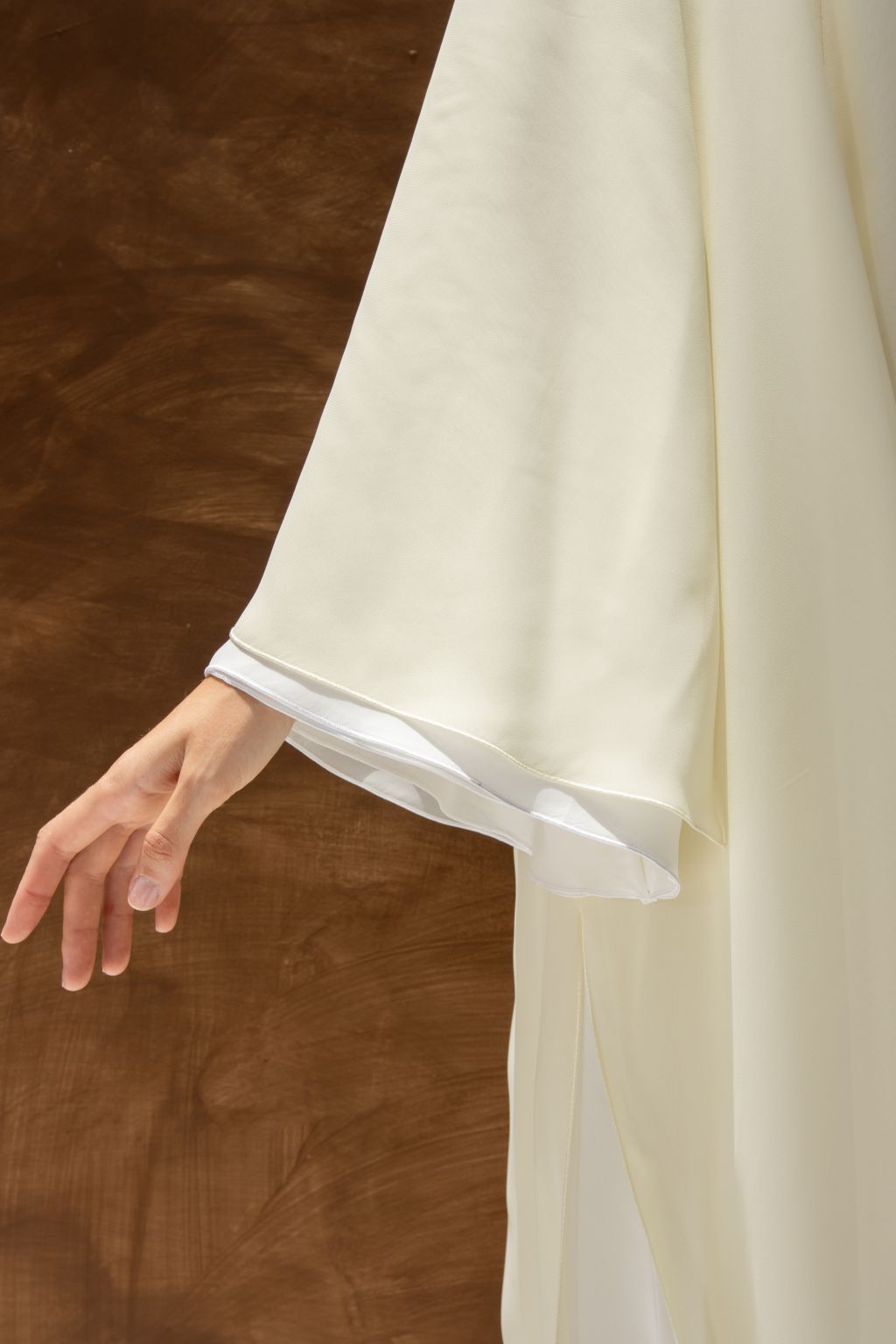 Close-up of white Layered Grace Abaya sleeve by Selected Lines showing flowing fabric and layered design