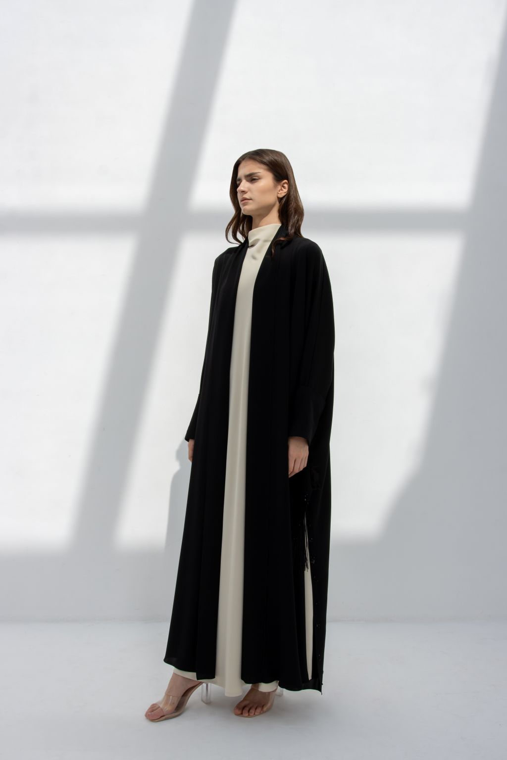 Luxury black abaya featuring a minimalist design with a cream-colored inner dress