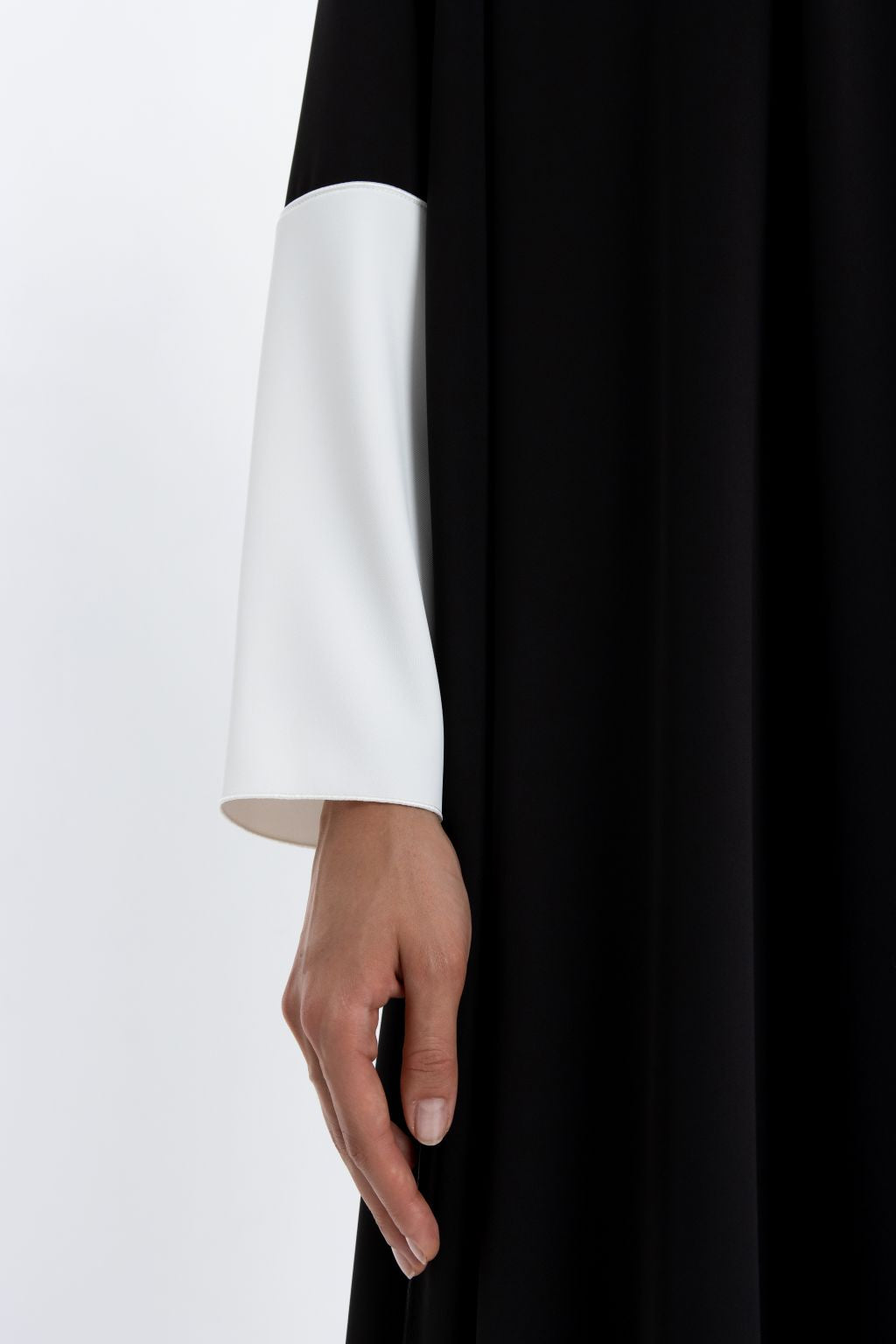 Luxury black and white abaya featuring elegant long sleeves and minimalist design