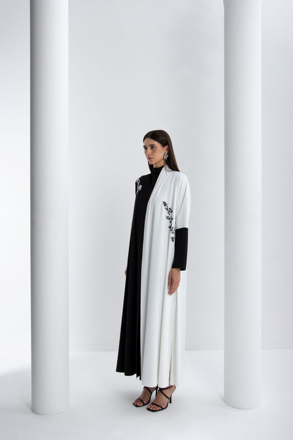 Luxury black and white abaya with elegant floral embellishments and a chic silhouette