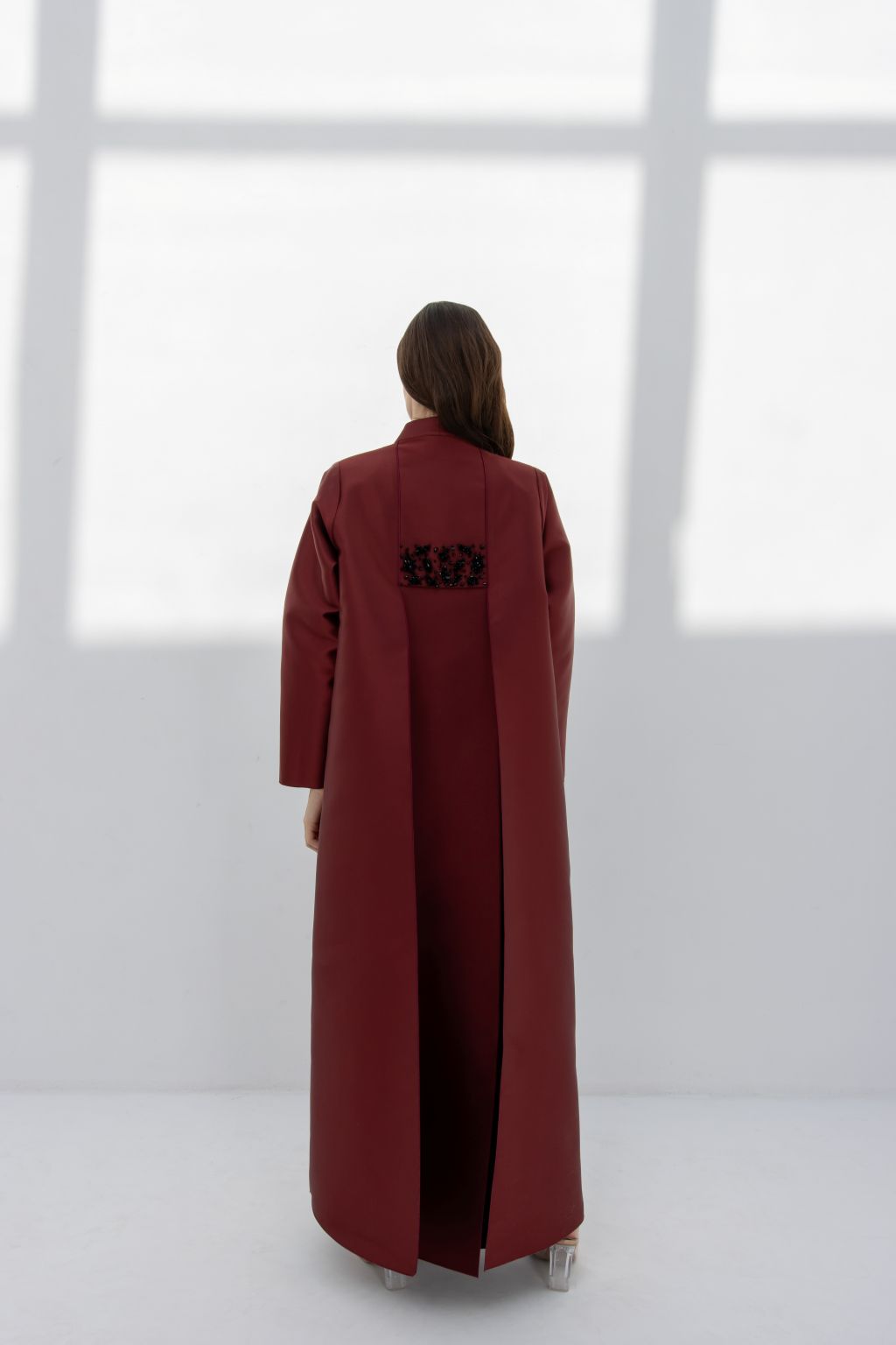 Elegant woman wearing a luxury burgundy women's coat with a sleek design and delicate detailing