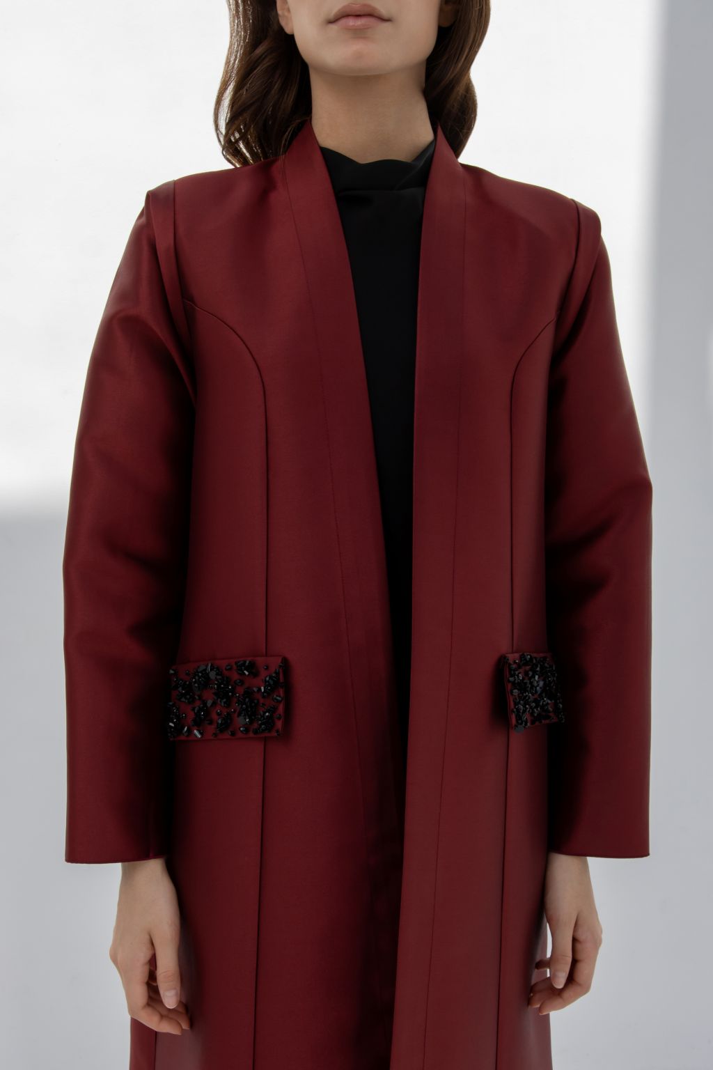 Luxury burgundy women's coat featuring unique embellishments and a sleek design for elegant occasions