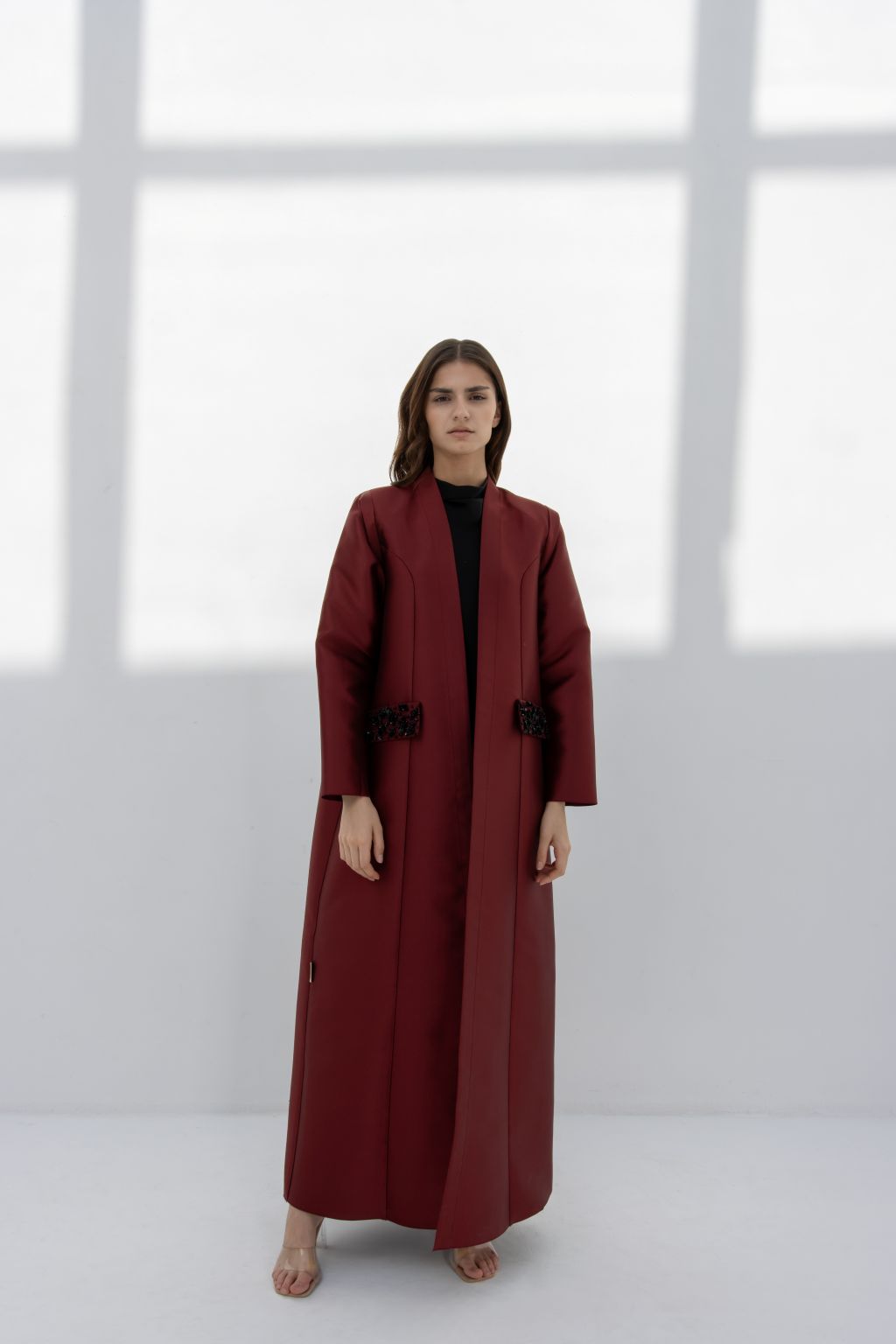 Luxury burgundy women's coat with elegant design and long sleeves showcased by a model