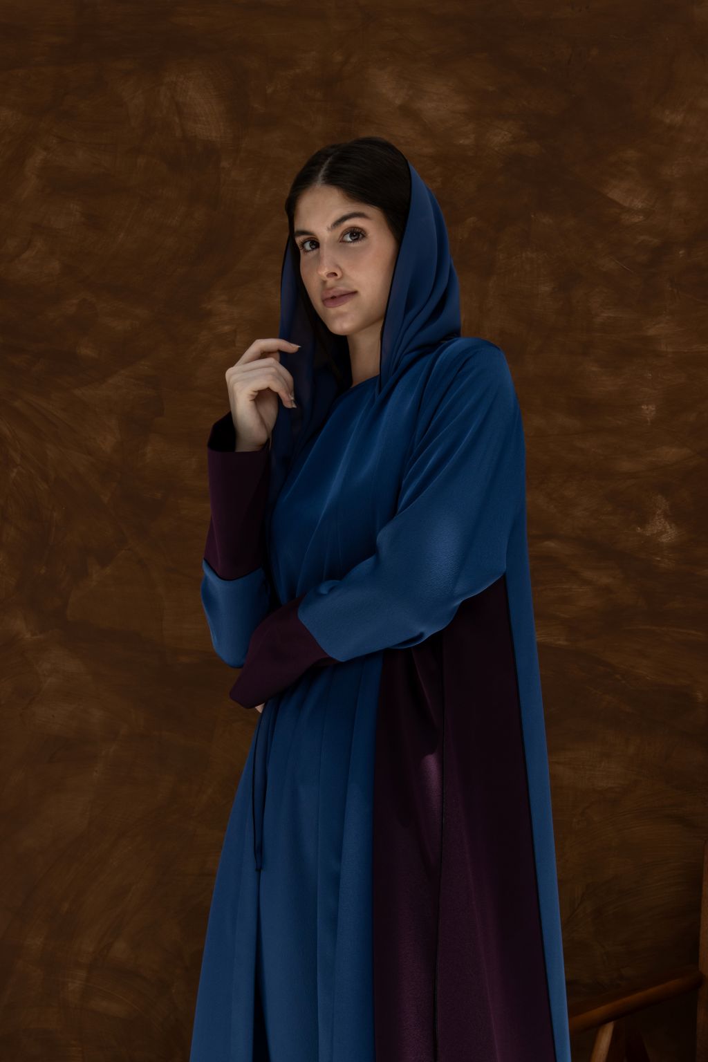 Selected Lines luxury HueLine blue abaya with hood and contrasting dark sleeves worn by a woman