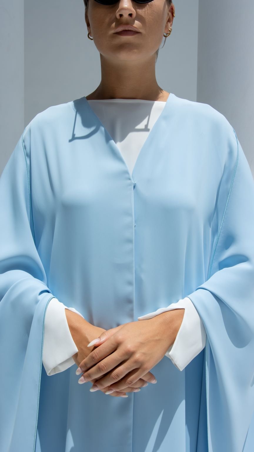 Elegant luxury Noura Abaya in light blue with a flowing silhouette and chic white accents