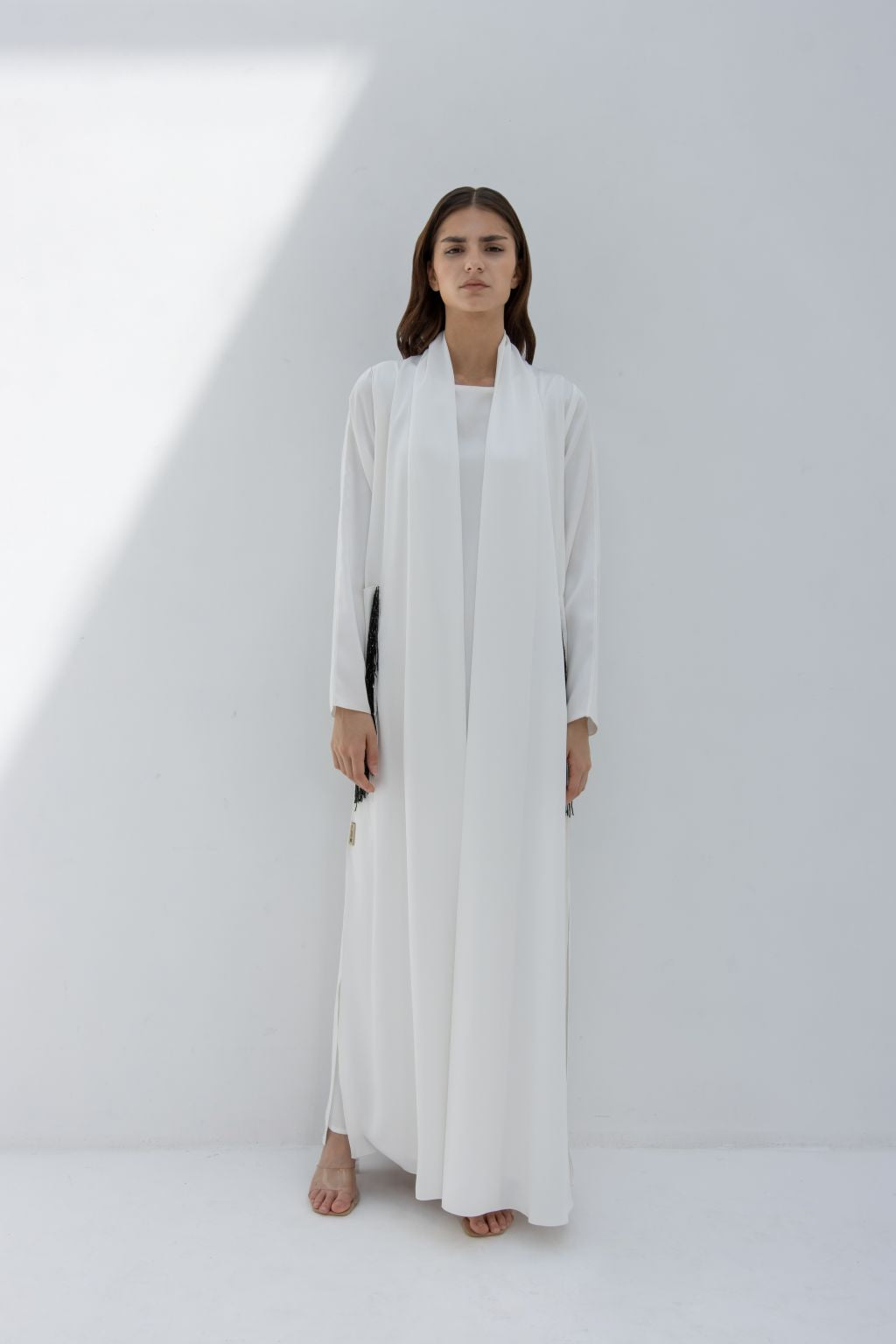 White luxury pocket tassel abaya by Selected Lines with long sleeves and open front design