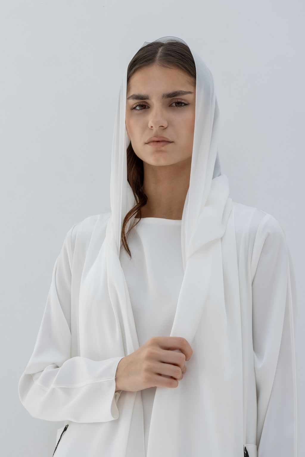 Selected Lines luxury pocket tassel abaya in white with hooded design on model