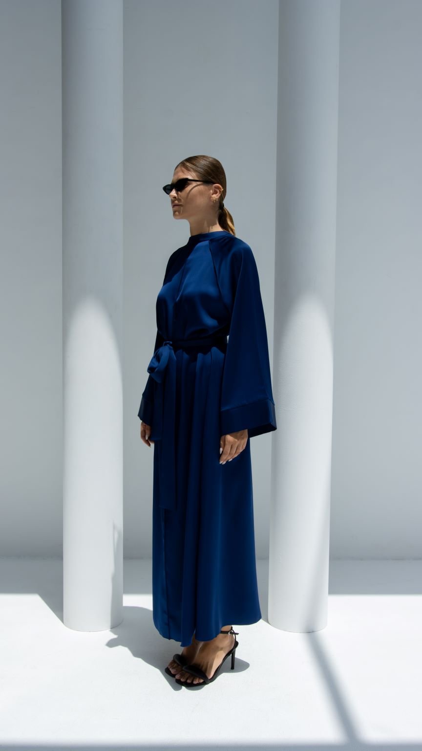 Elegant luxury silk belt dress in deep blue with long sleeves and a flowing silhouette