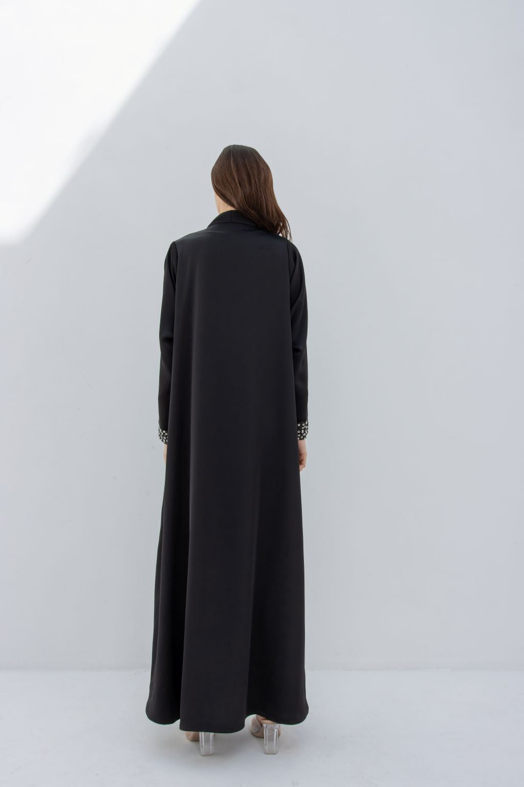 Rear view of woman wearing luxury silver crystal abaya in black by Selected Lines with detailed cuffs