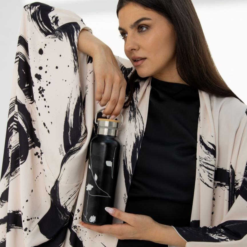 Selected Lines luxury tumbler with floral design held by a woman wearing a black and white patterned outfit