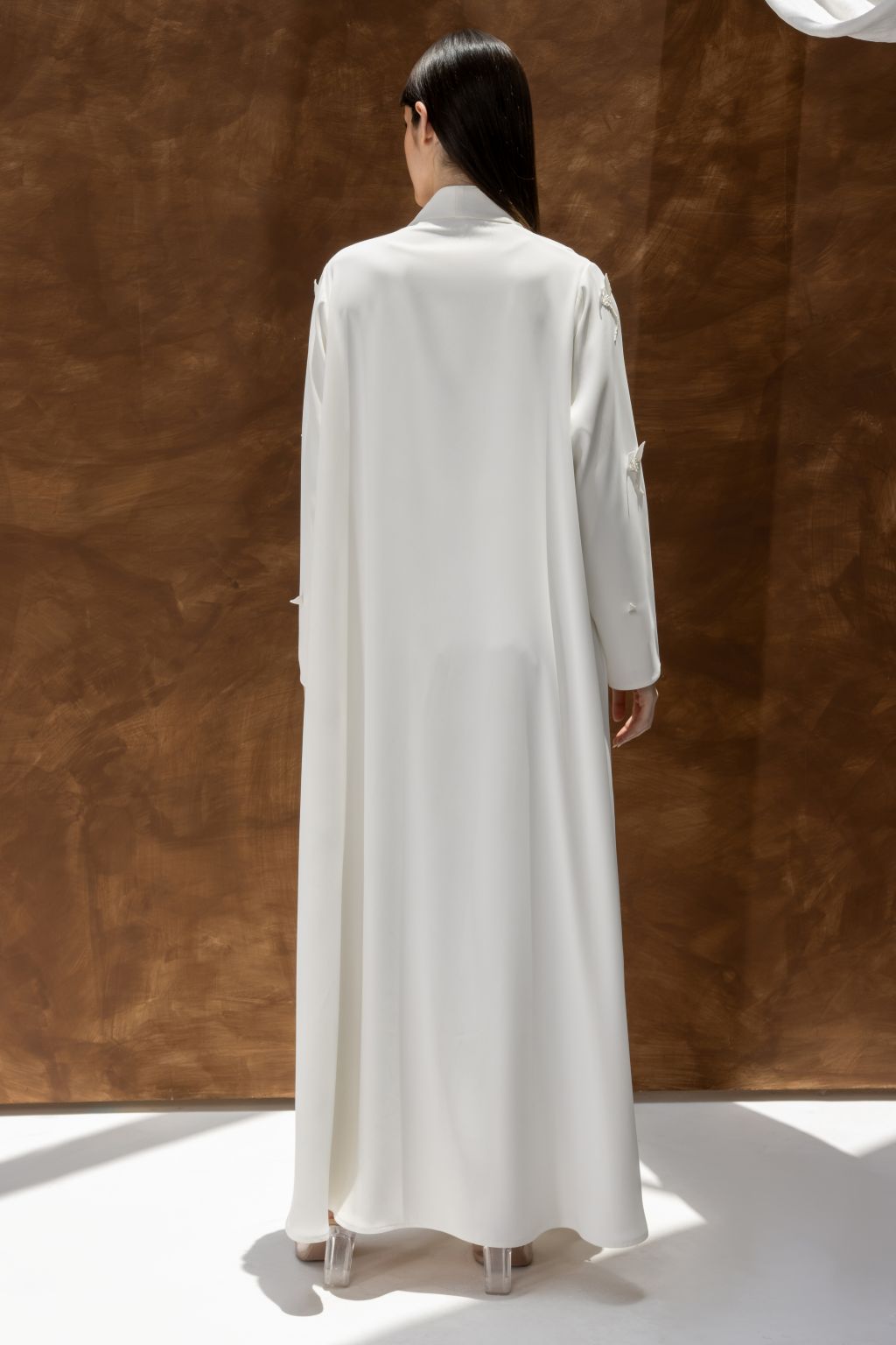 Selected Lines luxury white abaya dress with long sleeves and flowing fabric shown from back