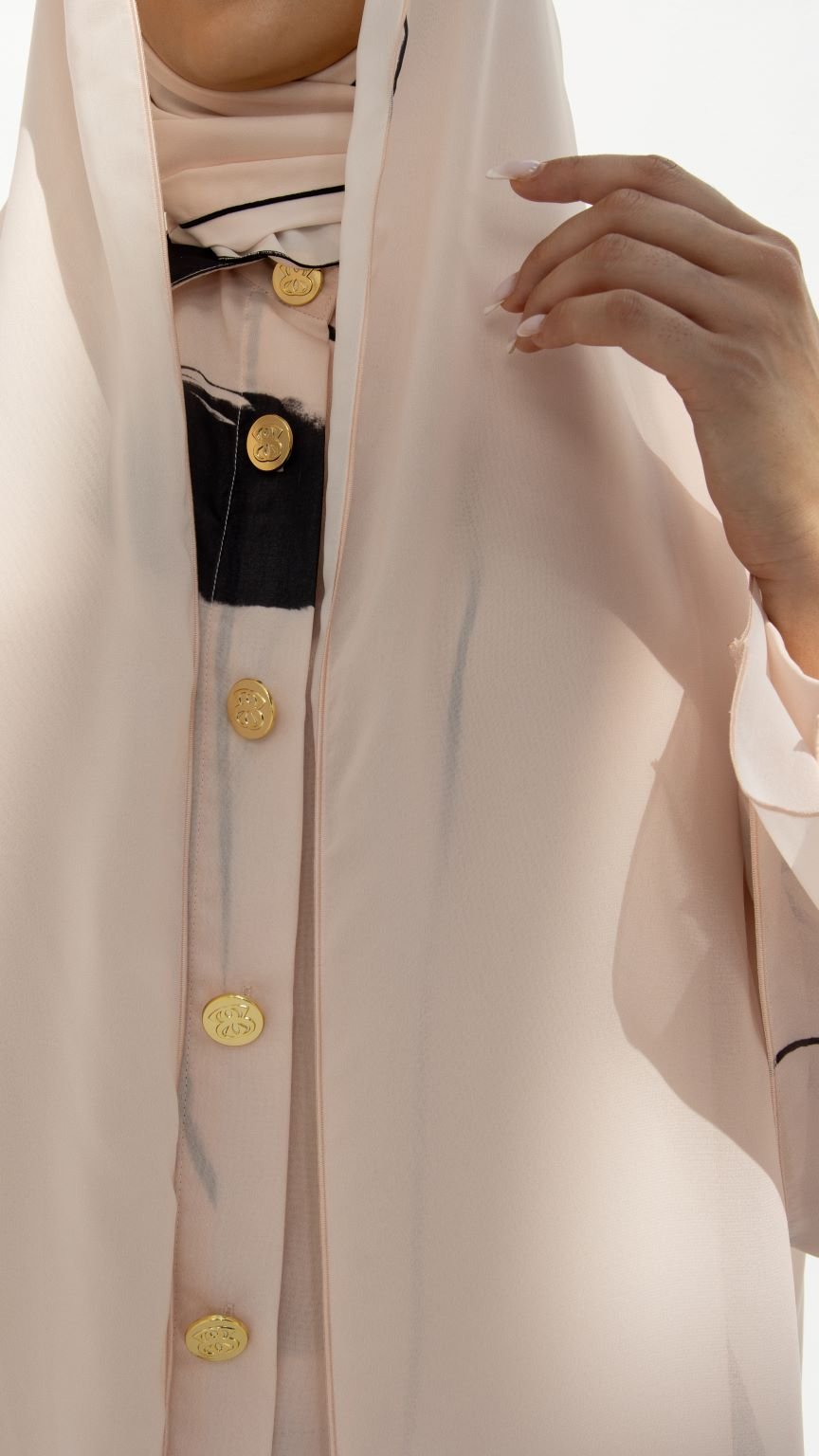 Selected Lines modest hoodie abaya with gold buttons and light pink fabric close-up