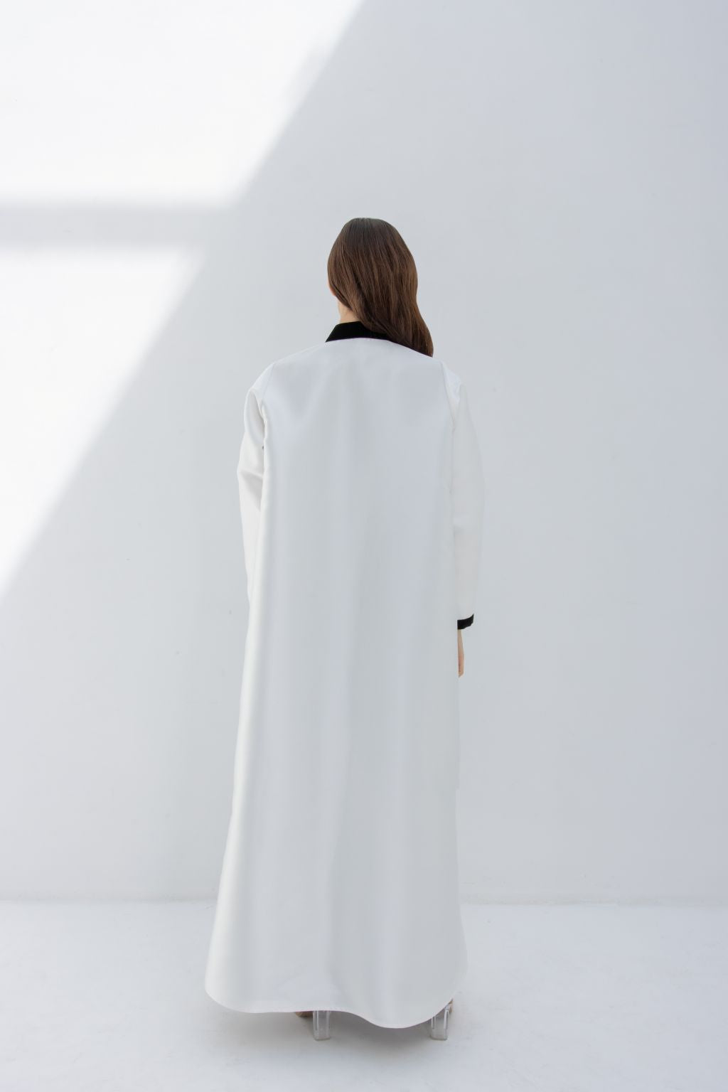 Selected Lines white abaya with black collar viewed from back showcasing Nka Design luxury fashion