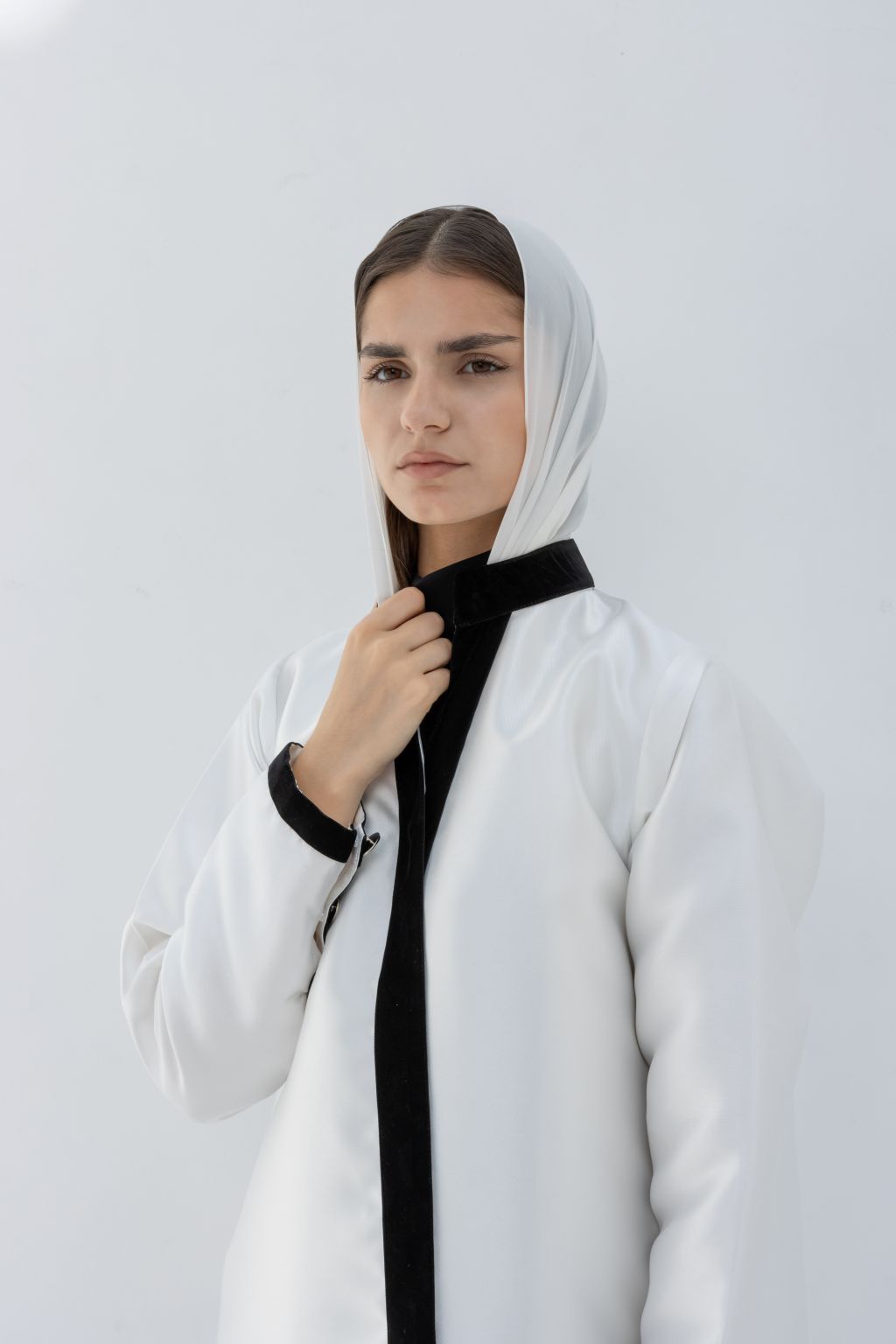 Selected Lines white abaya with black trim worn by woman featuring Nka Design luxury fashion style