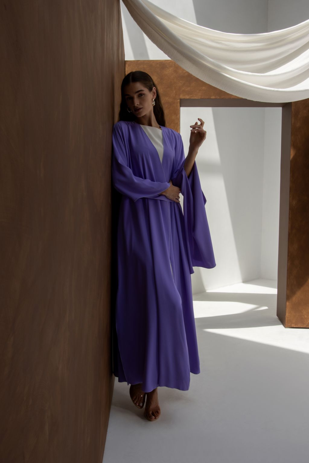 Selected Lines Onz SLC Signature robe in purple worn by woman leaning against wall in minimalistic room