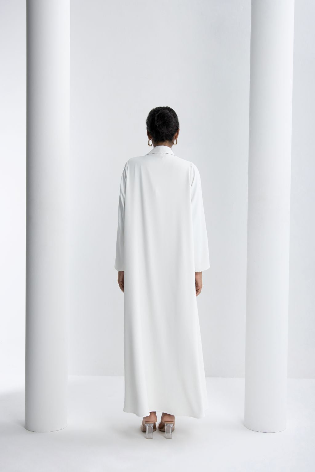 Elegant white refined abaya for special occasions with a modest design and long sleeves