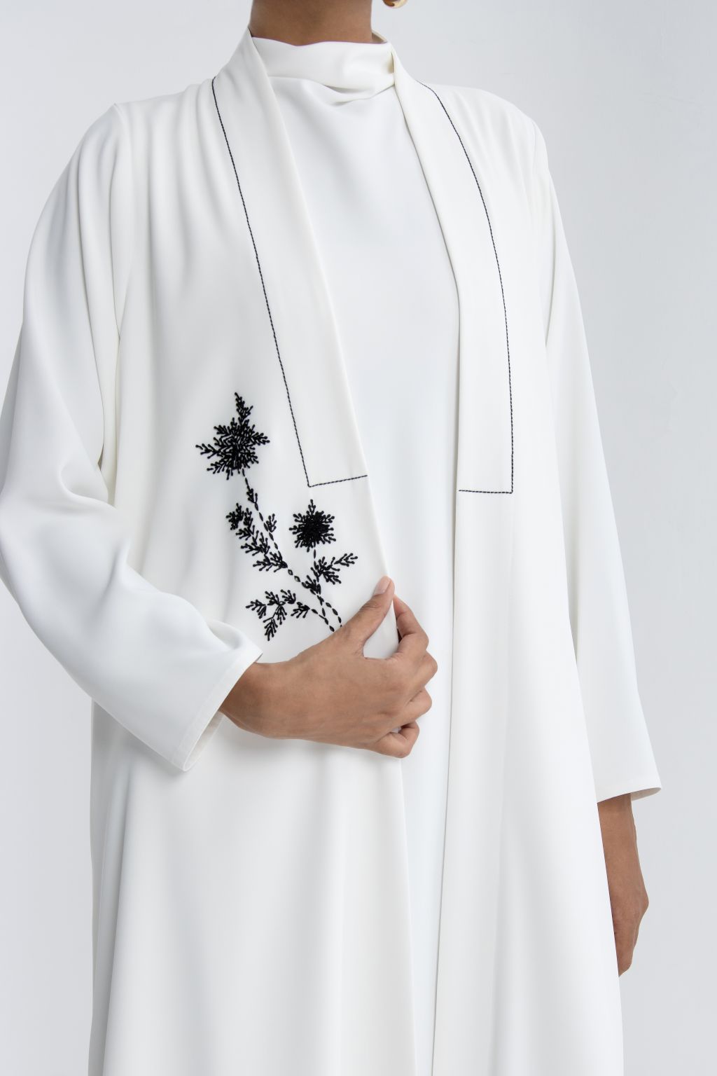 Elegant white refined abaya for special occasions featuring floral embroidery detail