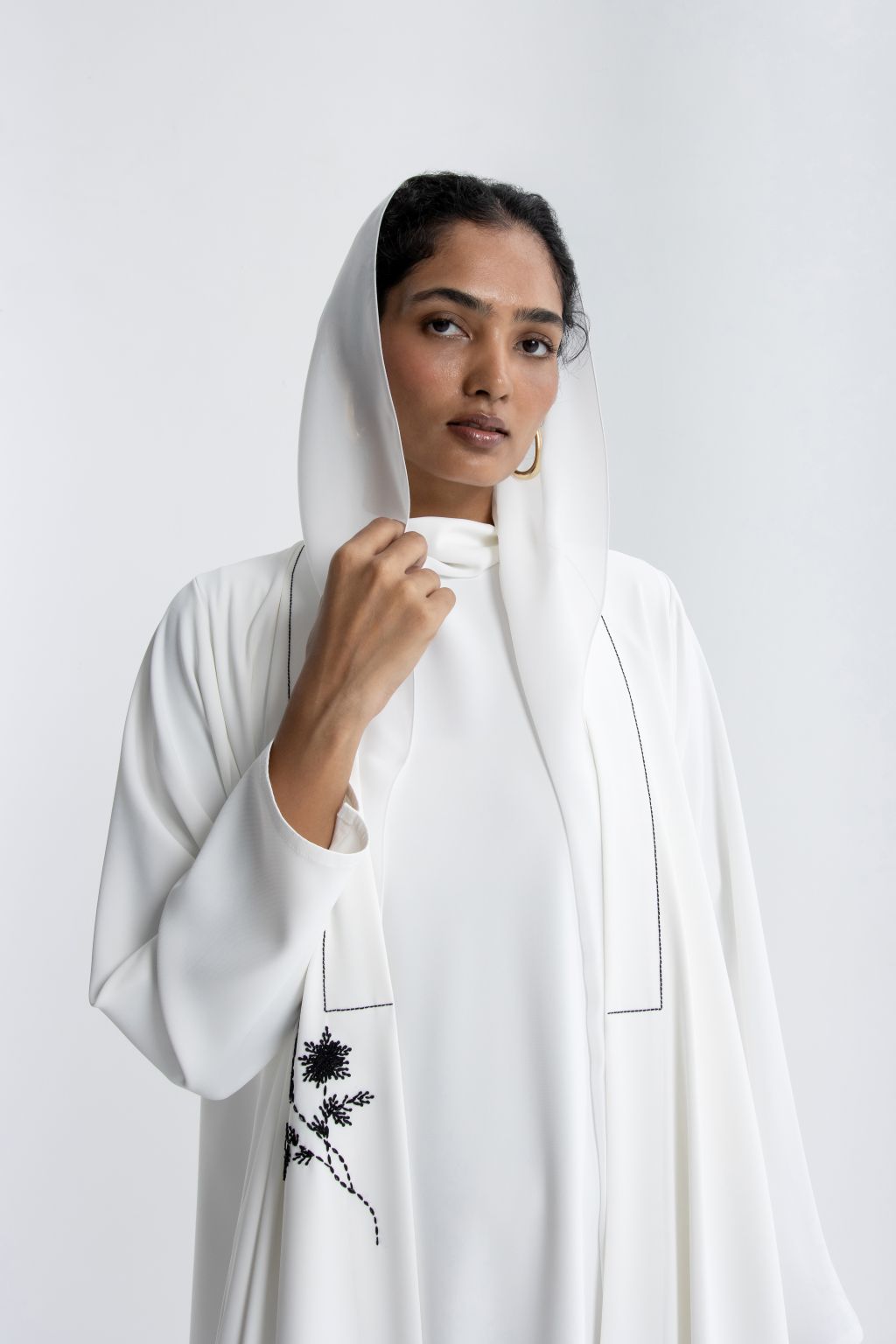 Elegant white refined abaya for special occasions with delicate embroidery detail and a hooded design