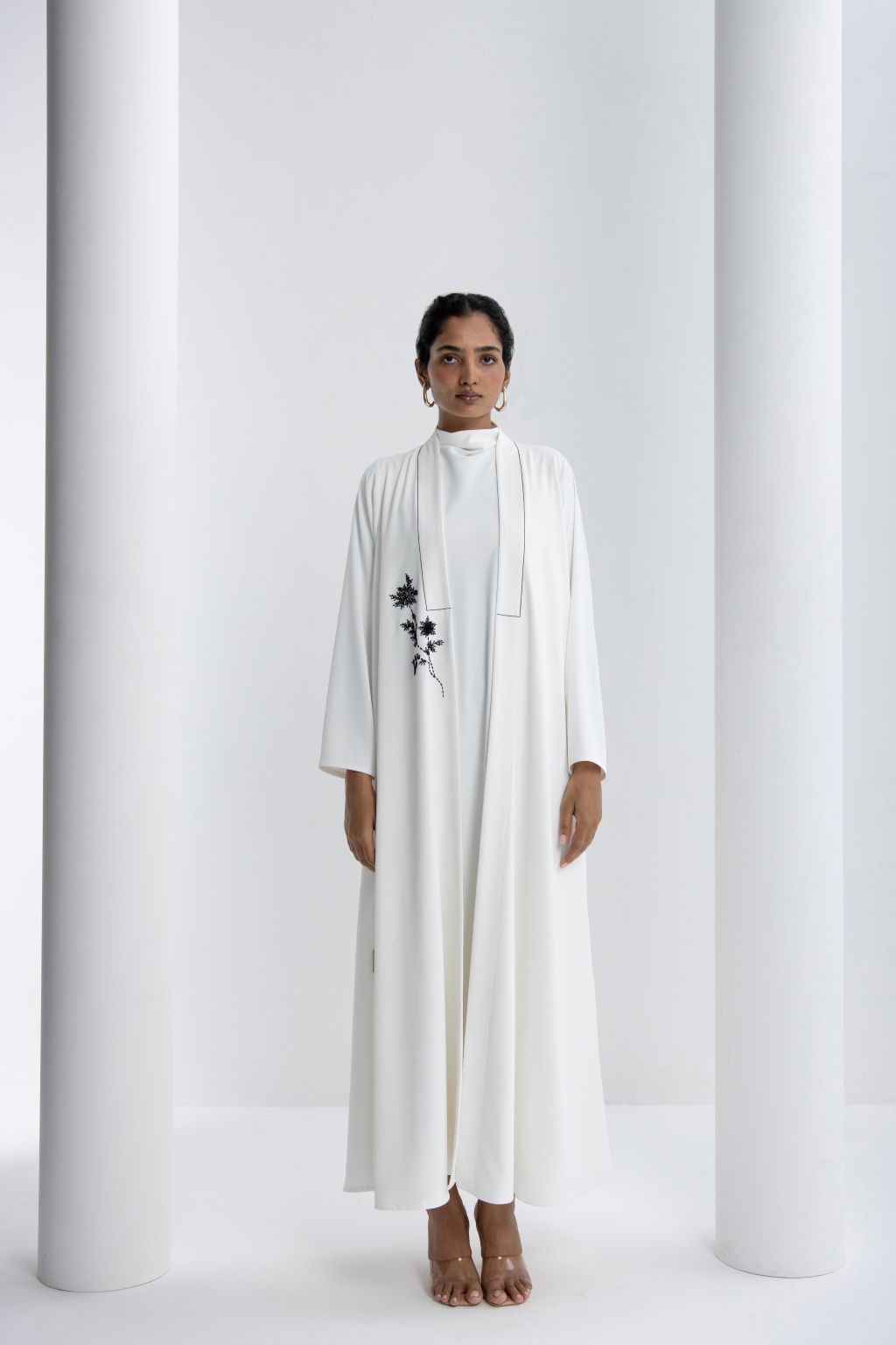 Elegant white refined abaya for special occasions featuring floral embroidery and a flowing design