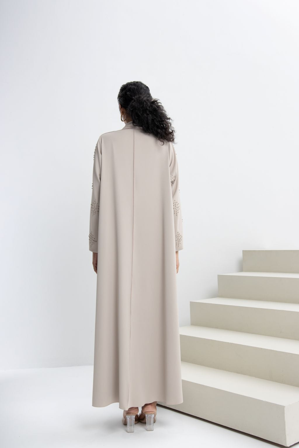 Back view of a refined neutral evening abaya with elegant details, perfect for formal occasions.