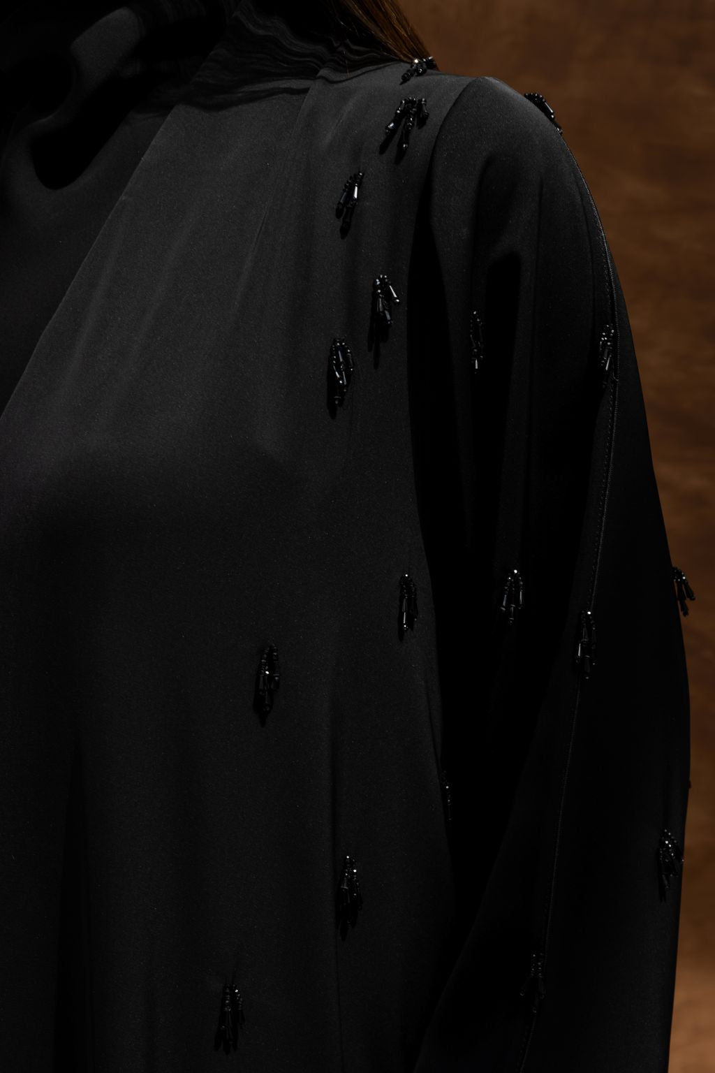 Selected Lines timeless black abaya gown with subtle beaded embellishments on a flowing sleeve