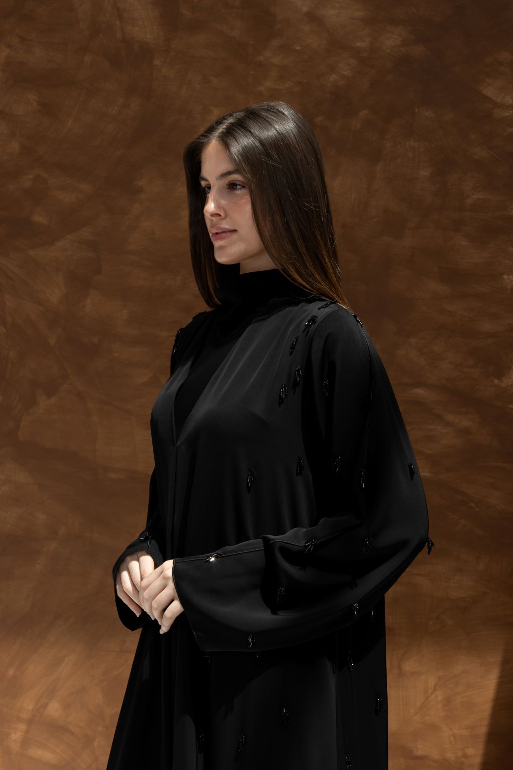 Selected Lines timeless black abaya gown with long sleeves and elegant draping on a model