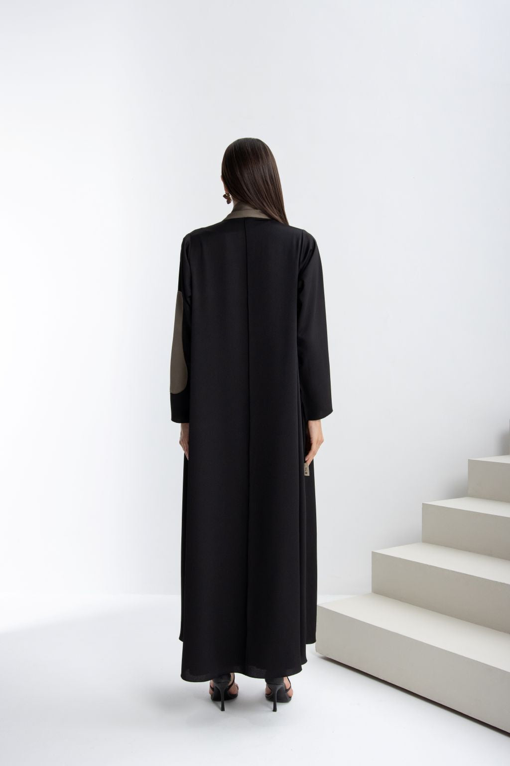Back view of a timeless handcrafted abaya in black, featuring elegant design and flowy silhouette.
